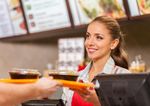 Fast food worker hands over food to customer