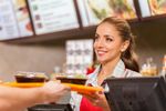 Fast food worker hands over food to customer
