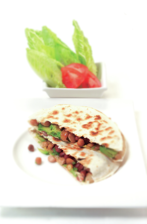 Tortillas filled with beans and avocado with a simple side salad