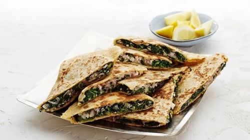 Triangle cut pieces of gozleme with spinach and cheese inside.