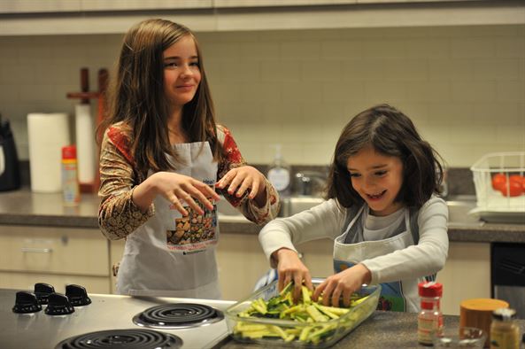 Two children having fun mixing food in the kitchen