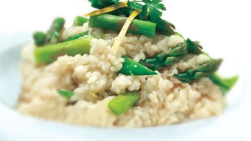 Bowl of rice risotto with cut up asparagus in it.