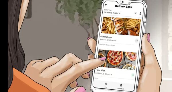Close up of the side of someone's face and a hand with pink nail polish scrolling on a phone. The phone has an app open called Deliver Eats, and two fast food restaurants are shown on the screen - Queen Burger and Pizza King.