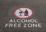 Close up of a section of bitumen road with ALCOHOL FREE ZONE written and a no alcohol graphic