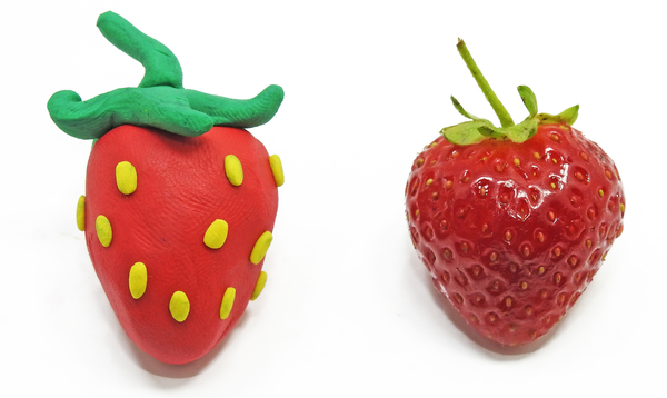 Close ups of a strawberry made of playdough and a real strawberry