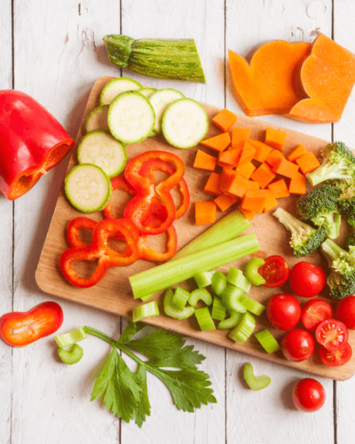 A chopping board with colourful vegetables cut up