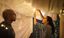 Man and woman string lights in a blanket fort