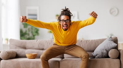 person jumping up from couch cheering