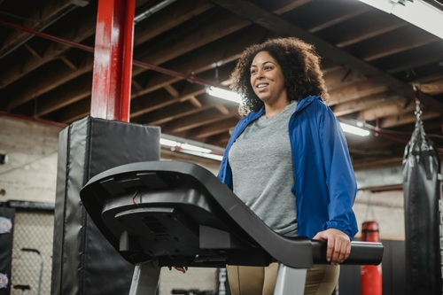 Woman standing on a treadmill looking determined