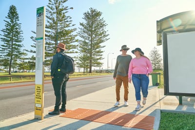 Man and woman walk to the bus stop