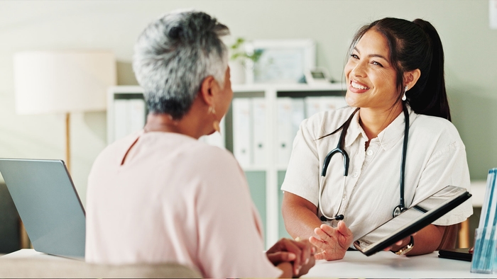 A doctor is smiling at her patient and sharing test results. 