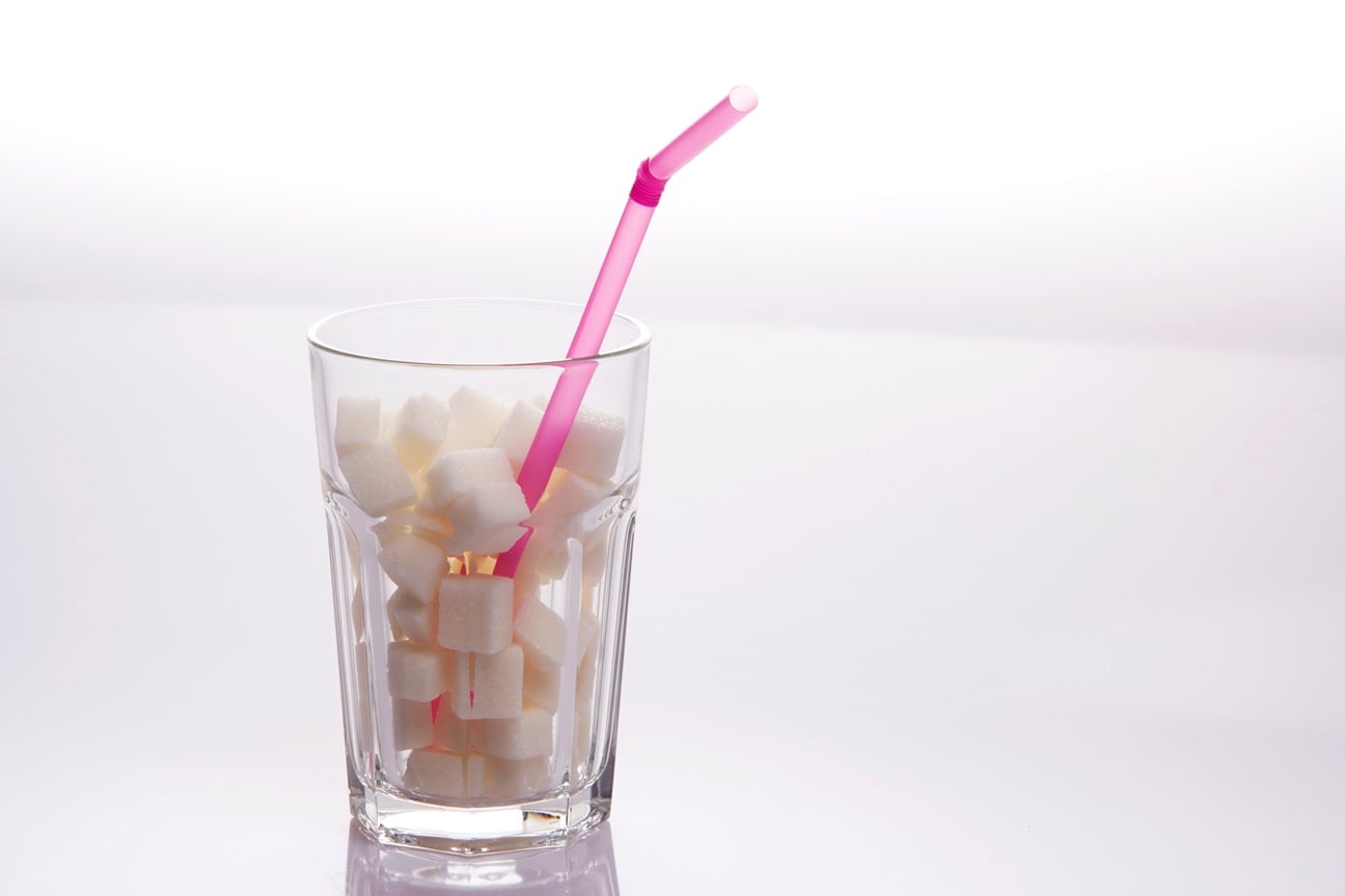 sugar cubes in a tall glass with a straw