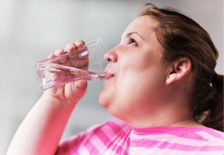 Woman drinks a glass of water