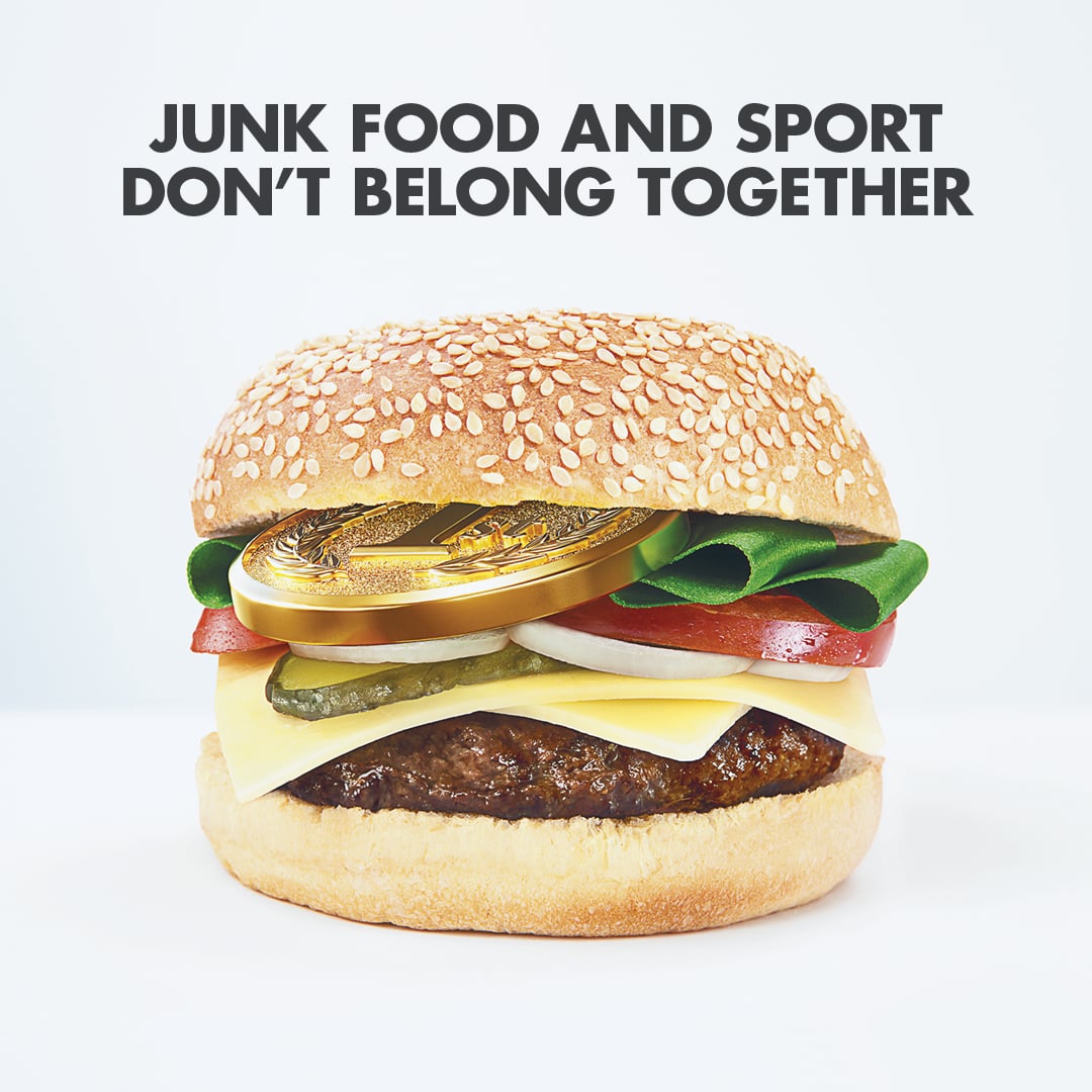 hamburger with a gold medal as one of the ingredients. Text reads 'Junk food and sport don't belong together'.