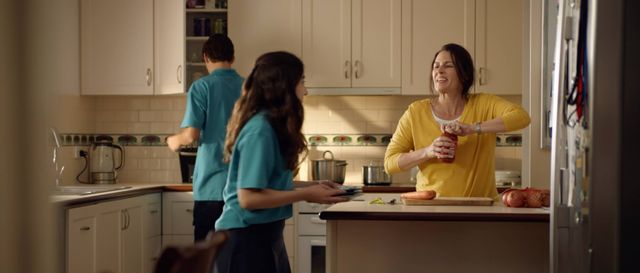 Still from the Menu App TV advertisement showing a mother and her two high school aged children making dinner together in the kitchen
