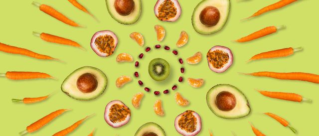 Kaleidoscope of colourful fruit and vegetables on a light green background