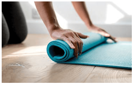 Woman rolls out a yoga mat