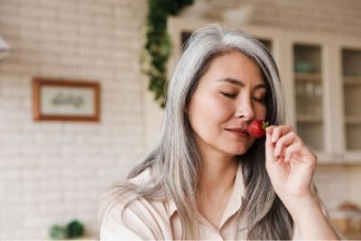 Lady enjoying a strawberry's scent