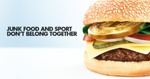 Burger with gold medal inside. Text reads 'junk food and sport don't belong together'.